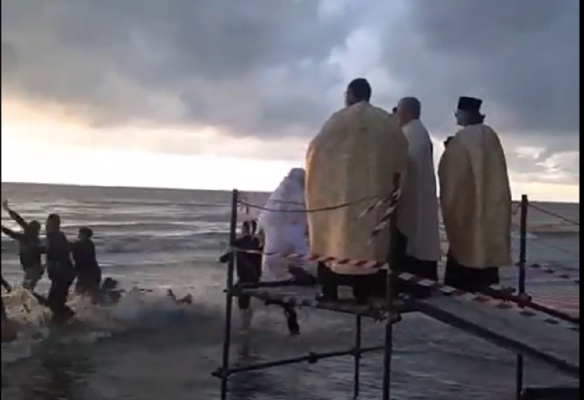 Un preot a căzut în mare când a vrut să arunce crucea de Bobotează! Video